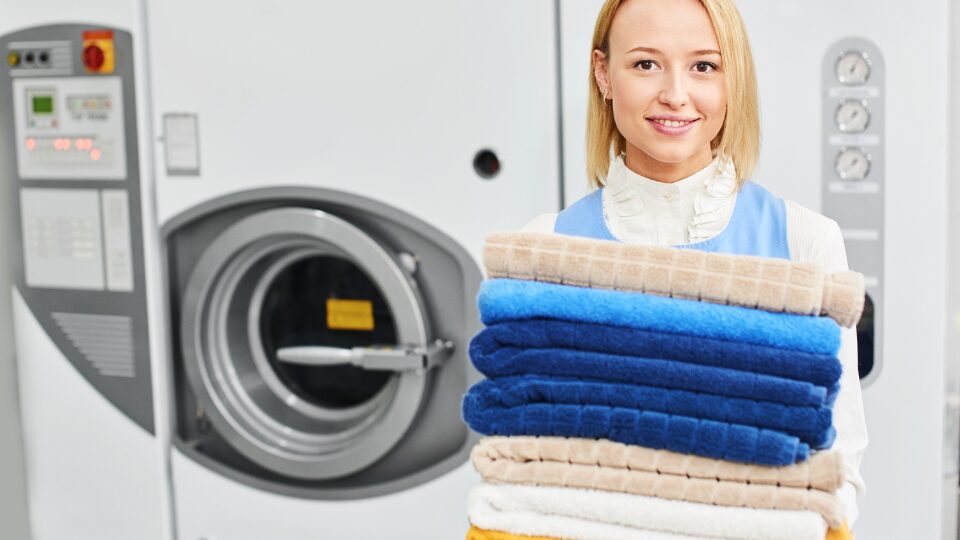 Girl worker holding a Laundry service clean towels